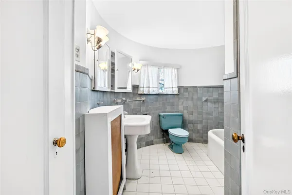 a bathroom with a toilet a sink and mirror