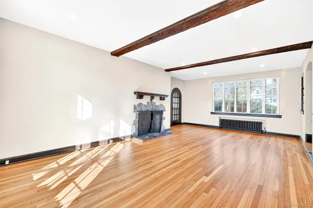a view of empty room with wooden floor and fireplace