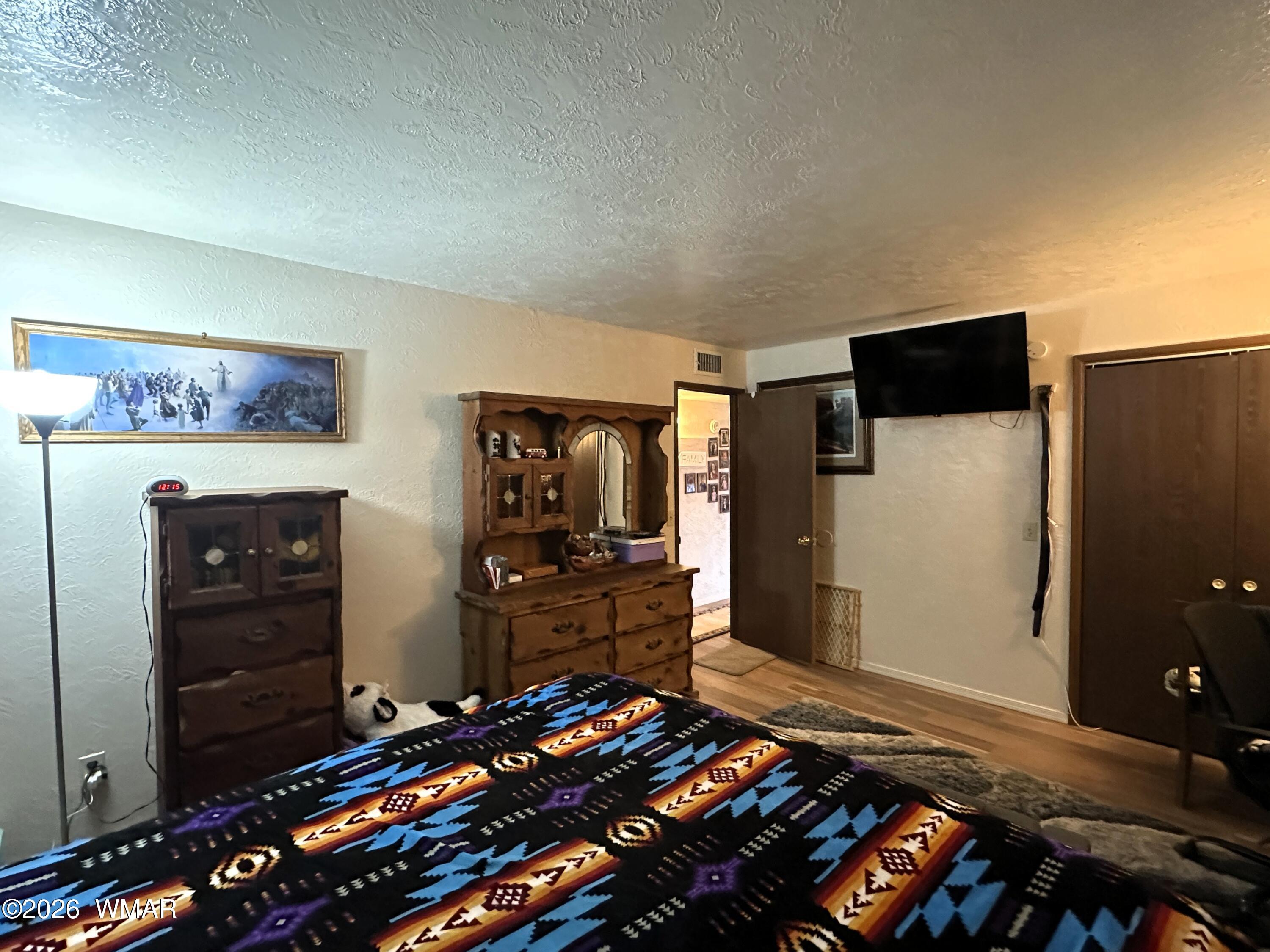19 County Road Alpine, AZ 85920 - Photo 14 of 27 a bedroom with a bed and a flat tv screen on dresser