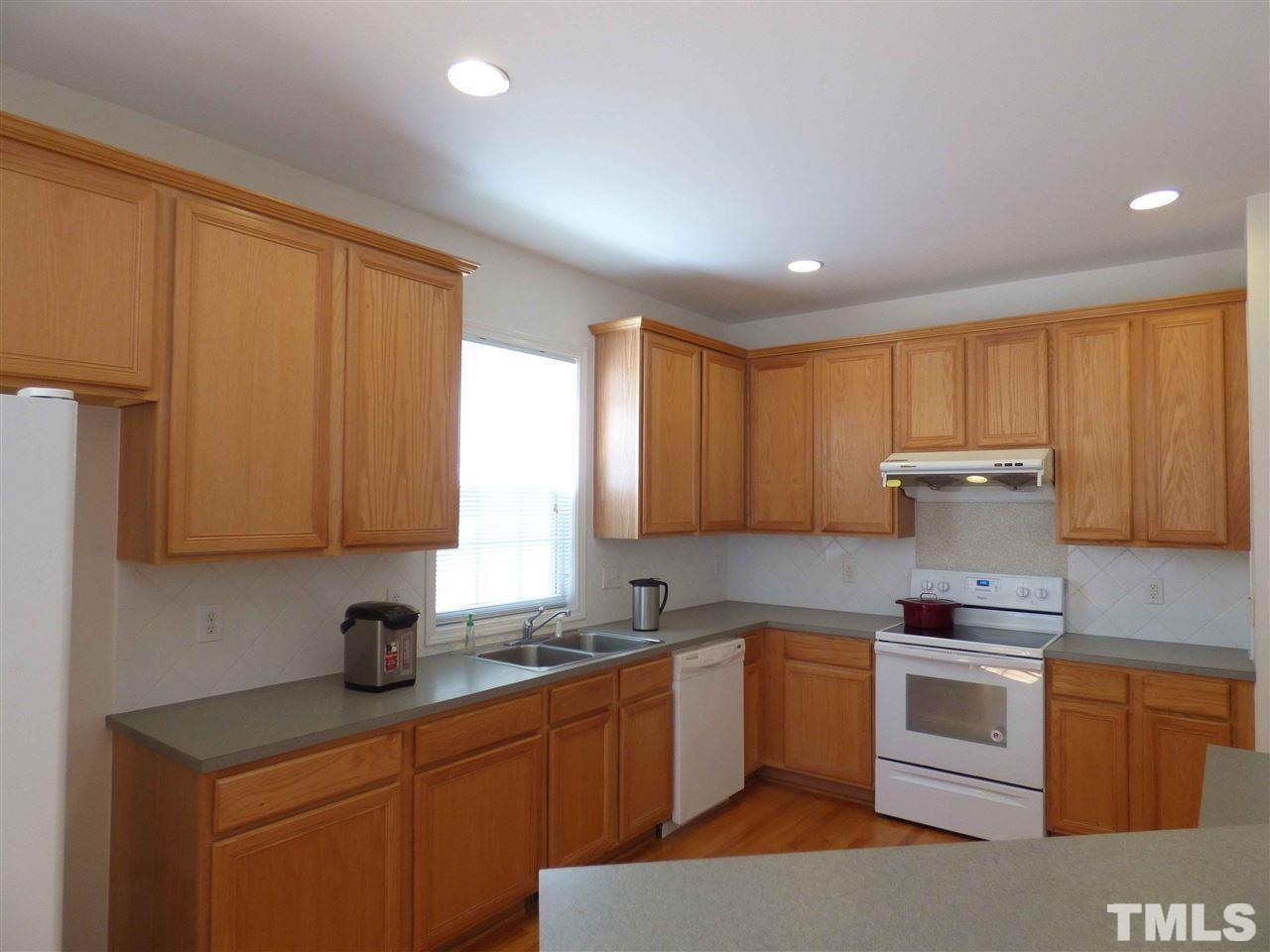 110 North Fields Circle Chapel Hill, NC 27516 - Photo 5 of 24 a kitchen with granite countertop a sink stainless steel appliances wooden cabinets and a window