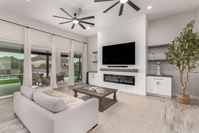 a bedroom with a bed a couches and a flat screen television