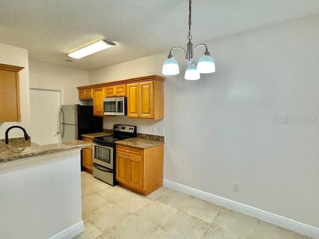 717 Secret Harbor Lane, Unit 309 Lake Mary, FL 32746 - Photo 6 of 20 a kitchen with stainless steel appliances granite countertop a sink a stove top oven a chimney and a window