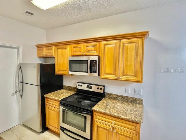 717 Secret Harbor Lane, Unit 309 Lake Mary, FL 32746 - Photo 8 of 20 a kitchen with a stove microwave and refrigerator