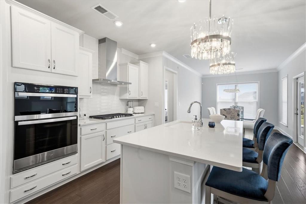 2457 Naples Street Hoschton, GA 30548 - Photo 6 of 41 a kitchen with stainless steel appliances a table chairs and a refrigerator
