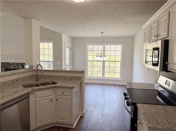 a kitchen with stainless steel appliances granite countertop a sink stove and cabinets