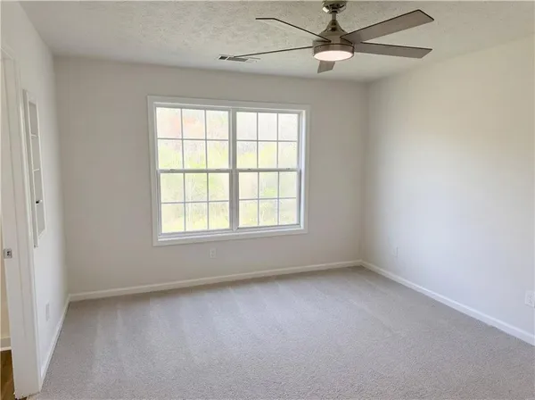an empty room with a window and a fan