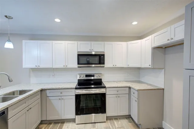 a kitchen with white cabinets and white appliances