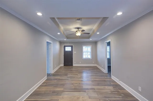 a view of a hallway with wooden floor and a chandelier