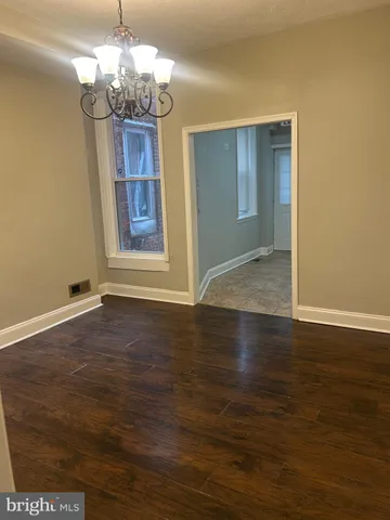 a view of a livingroom with a chandelier wooden floor and chandelier