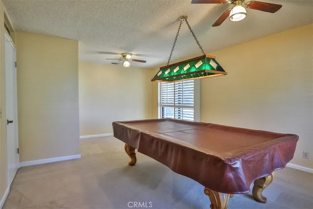 a room with pool table and windows