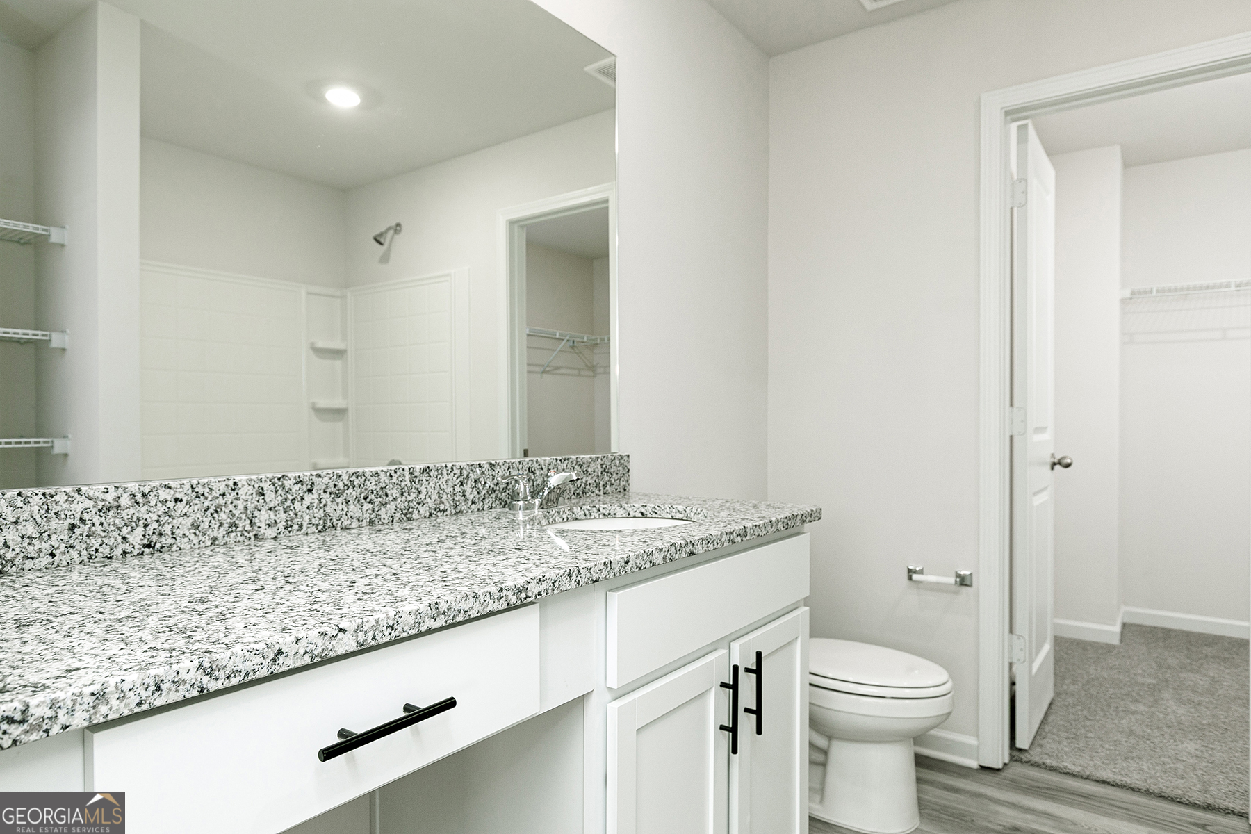 642 Mackenzie Cove Villa Rica, GA 30180 - Photo 13 of 17 a bathroom with a granite countertop sink a toilet and a mirror