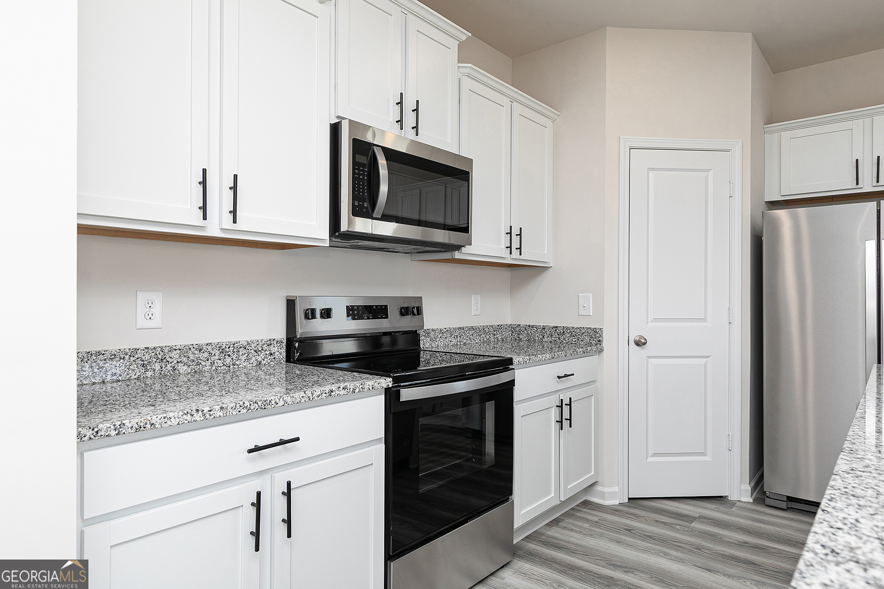 642 Mackenzie Cove Villa Rica, GA 30180 - Photo 8 of 17 a kitchen with stainless steel appliances granite countertop white cabinets and a stove a oven with white countertops