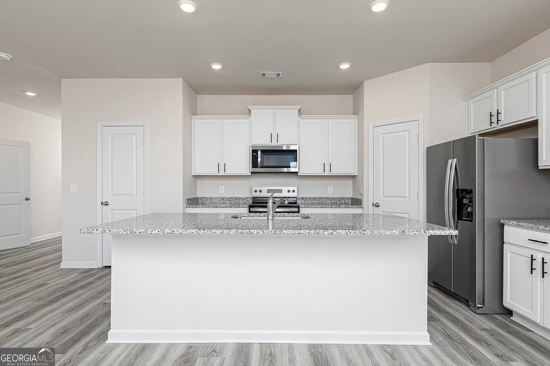 642 Mackenzie Cove Villa Rica, GA 30180 - Photo 9 of 17 a large kitchen with stainless steel appliances granite countertop a refrigerator a stove a sink and white cabinets with wooden floor