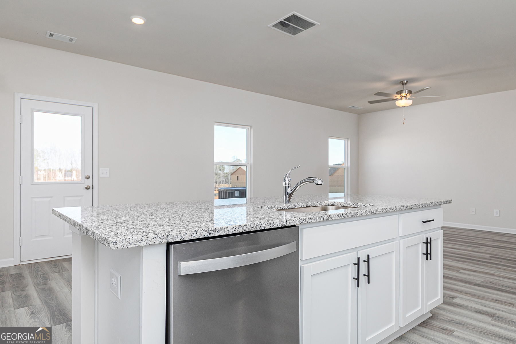 642 Mackenzie Cove Villa Rica, GA 30180 - Photo 10 of 17 a kitchen with a sink dishwasher and white cabinets with wooden floor