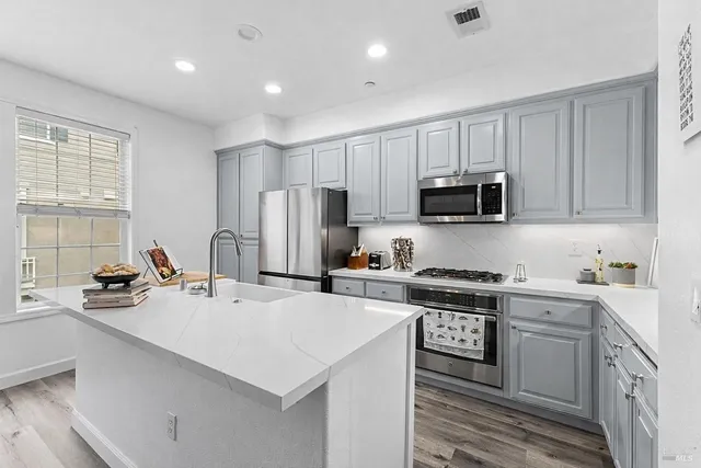 a kitchen with stainless steel appliances a refrigerator stove microwave and sink