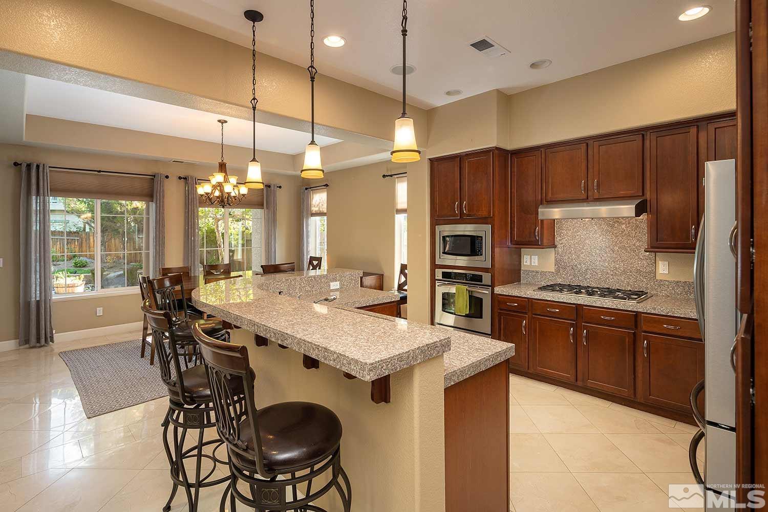 1861 Braemore Drive Reno, NV 89521 - Photo 4 of 40 a kitchen with stainless steel appliances granite countertop a stove a refrigerator a oven a sink with a dining table and chairs