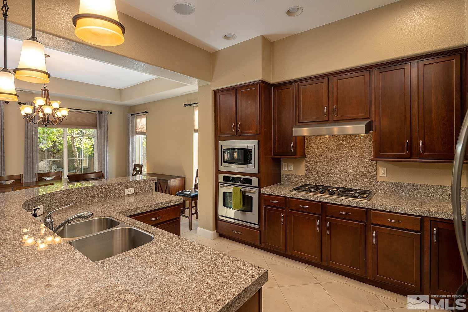 1861 Braemore Drive Reno, NV 89521 - Photo 5 of 40 a kitchen with stainless steel appliances granite countertop a sink stove and refrigerator