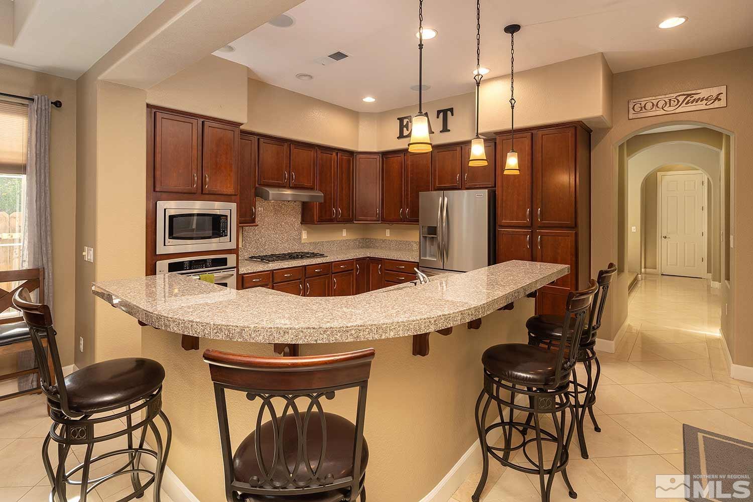1861 Braemore Drive Reno, NV 89521 - Photo 8 of 40 a kitchen with stainless steel appliances granite countertop a sink a stove and a refrigerator
