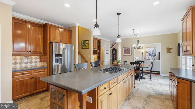 a kitchen with stainless steel appliances granite countertop a stove a refrigerator and a wooden cabinets