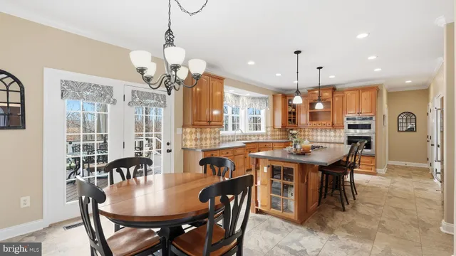 a dining room filled chandelier and wooden floor