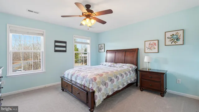 a bedroom with a bed chandelier and a window