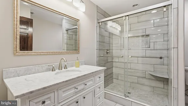 a bathroom with a granite countertop sink a shower and a mirror