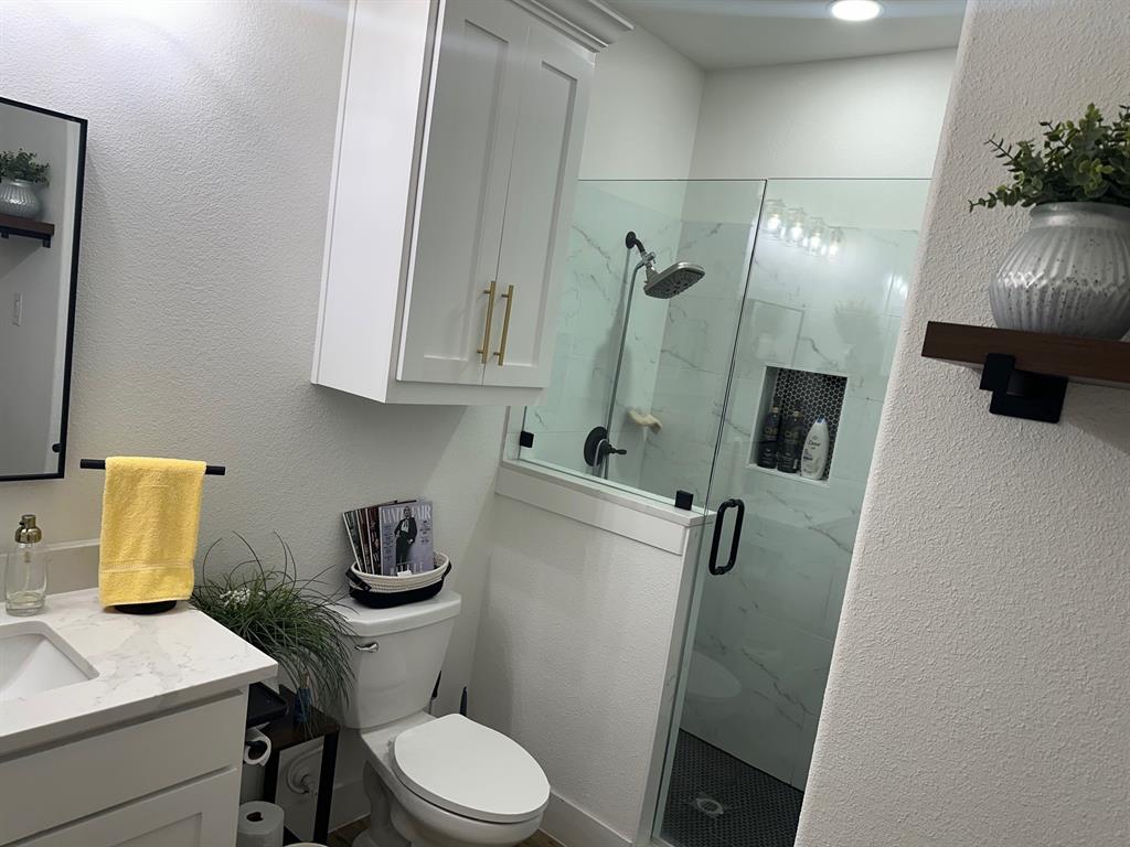 351 Mesa Ridge Decatur, TX 76234 - Photo 17 of 29 Bathroom with a textured wall, a marble finish shower, and vanity
