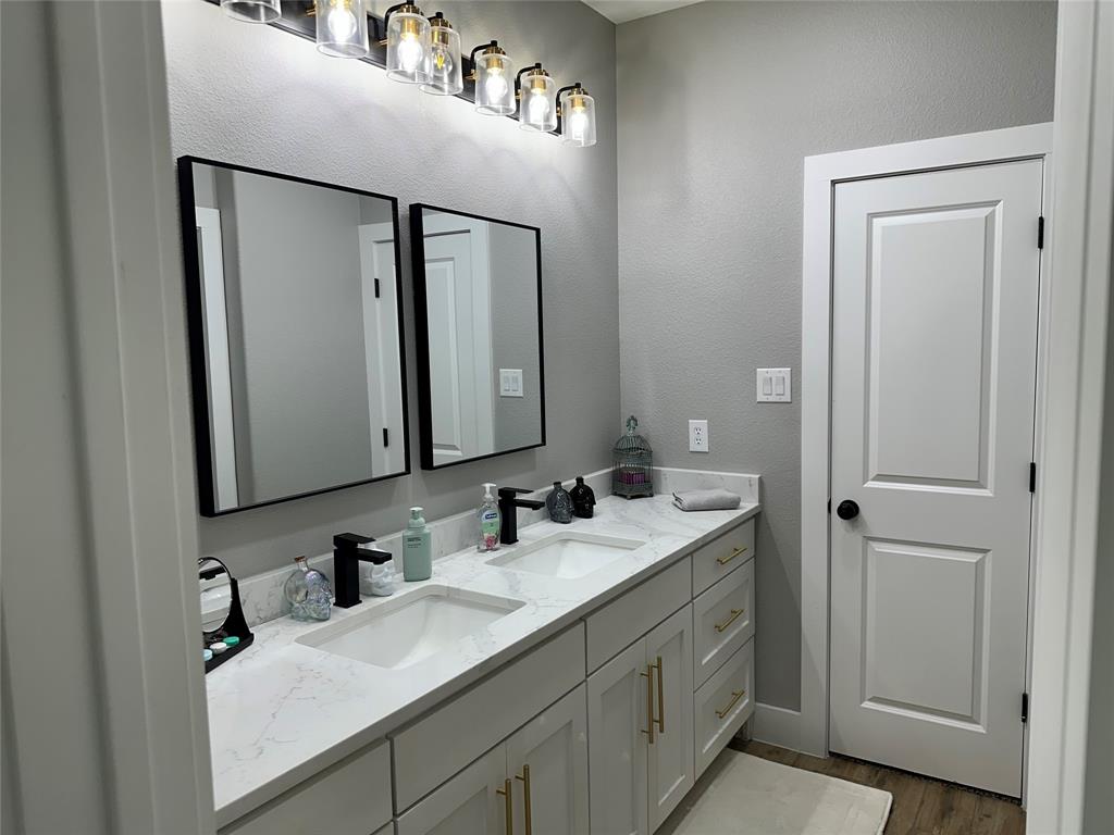 351 Mesa Ridge Decatur, TX 76234 - Photo 22 of 29 Bathroom featuring double vanity, wood finished floors, and a textured wall