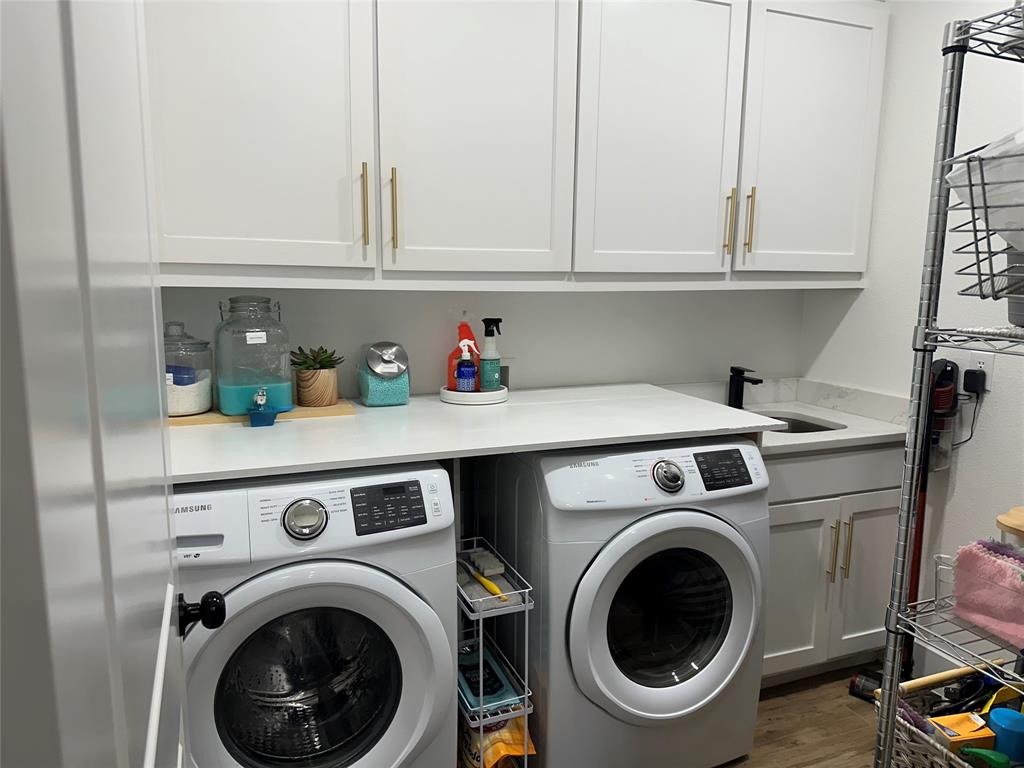 351 Mesa Ridge Decatur, TX 76234 - Photo 23 of 29 Laundry room featuring washer and clothes dryer, cabinet space, and wood finished floors