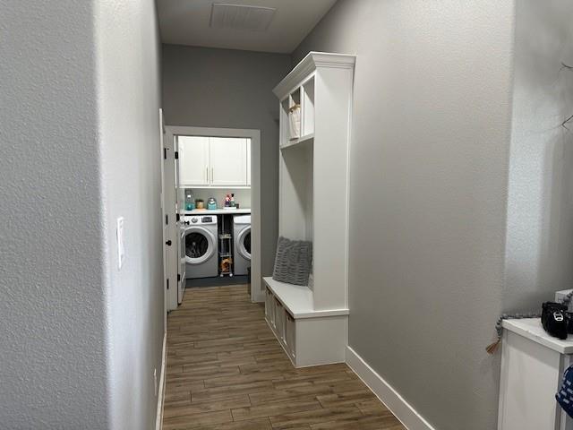 351 Mesa Ridge Decatur, TX 76234 - Photo 9 of 29 Washroom featuring washer and clothes dryer, dark wood-type flooring, a textured wall, and cabinet space