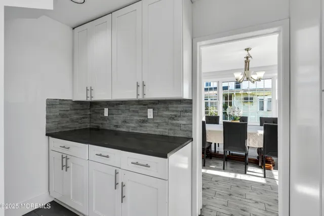 a kitchen with granite countertop white cabinets and white appliances