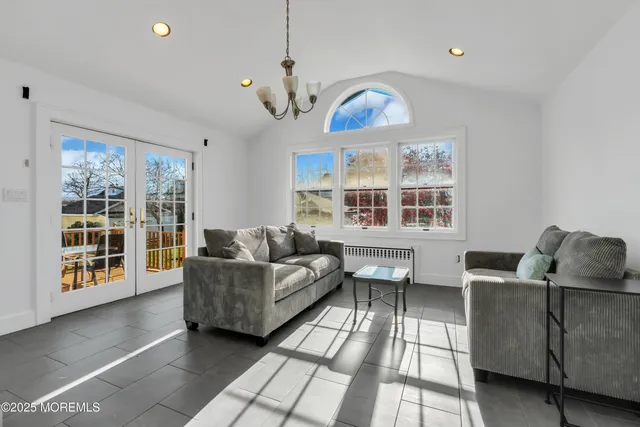 a living room with furniture a flat screen tv and a large window