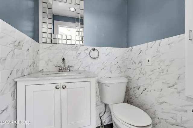 a bathroom with a granite countertop toilet sink and mirror