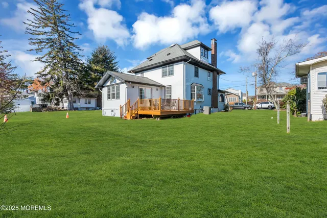 a front view of a house with a garden and trees