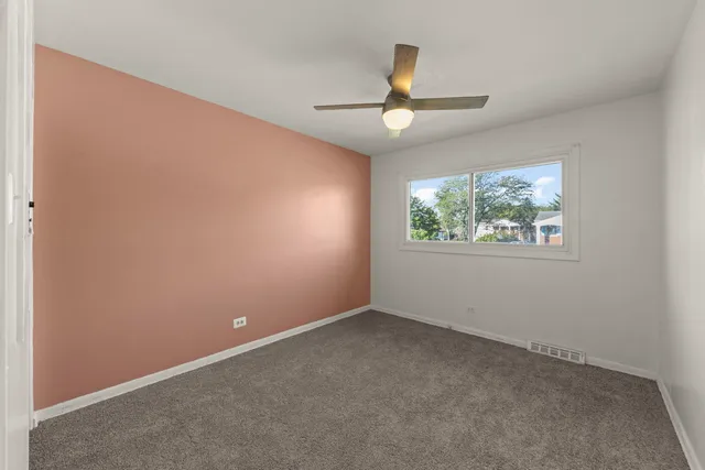 an empty room with a window and a ceiling fan