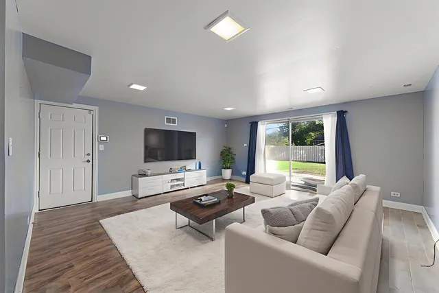 a living room with furniture wooden floor and a flat screen tv