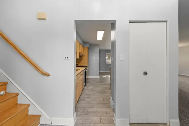 a view of a hallway with wooden floor and staircase