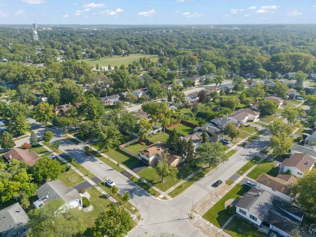 an aerial view of residential houses with outdoor space and trees
