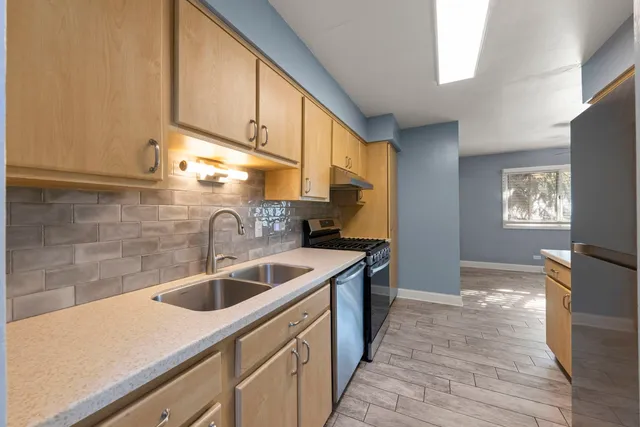 a kitchen with a sink cabinets and a wooden floor