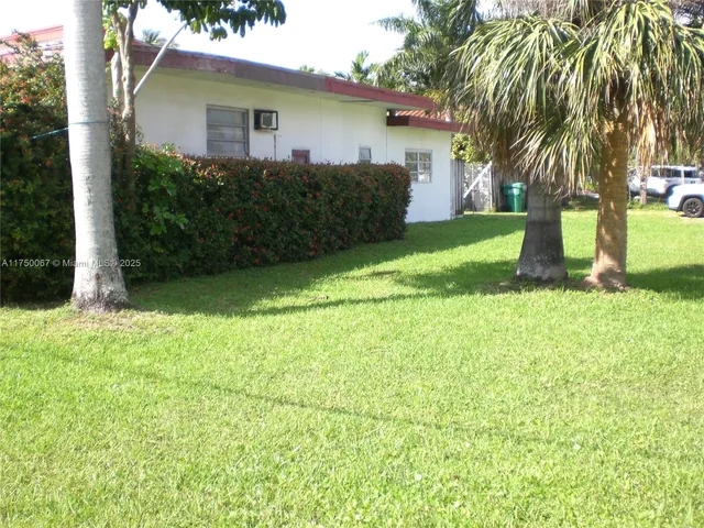 a view of a house with backyard and a tree