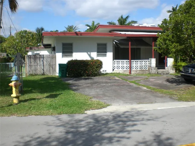 a front view of a house with a yard and potted plants