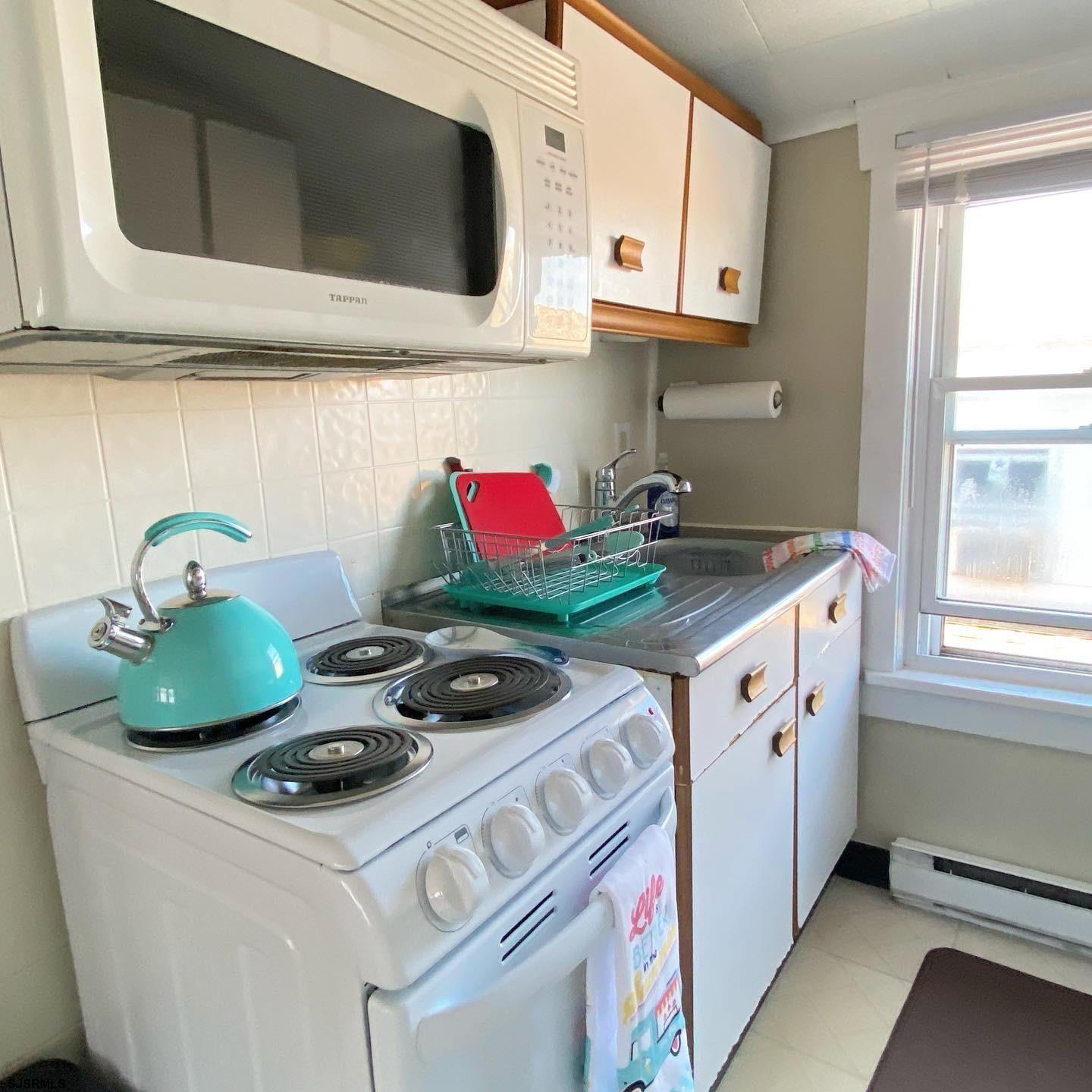 608 1st Street, Unit 3 Ocean City, NJ 08226 - Photo 4 of 13 a kitchen with stainless steel appliances a stove a microwave and cabinets
