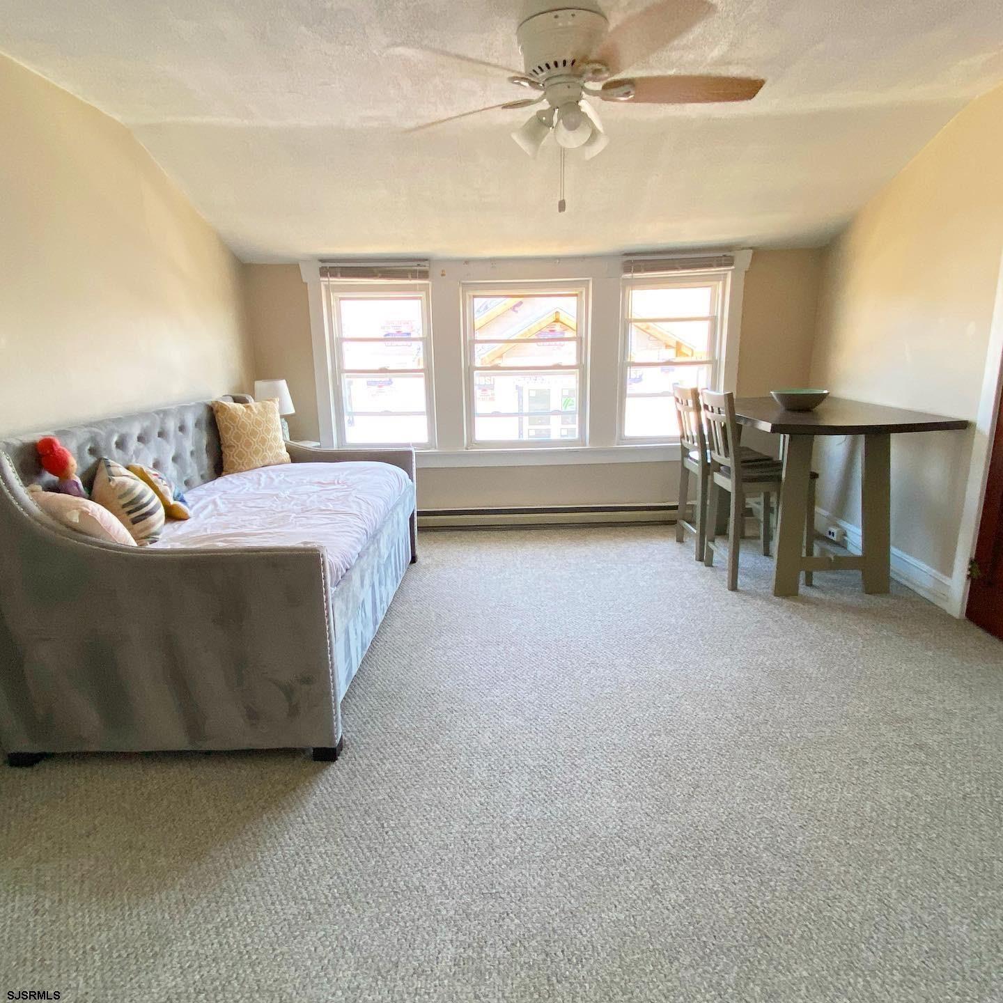 608 1st Street, Unit 3 Ocean City, NJ 08226 - Photo 6 of 13 a spacious bedroom with a bed and a chandelier