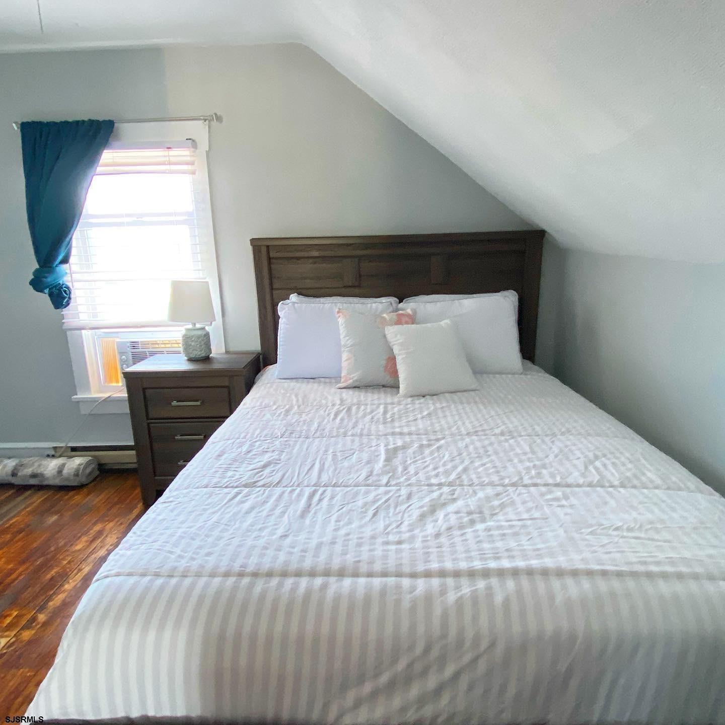 608 1st Street, Unit 3 Ocean City, NJ 08226 - Photo 7 of 13 a bedroom with a bed and wooden floor