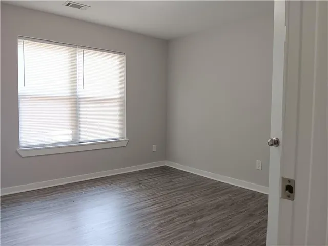 an empty room with wooden floor & closet area