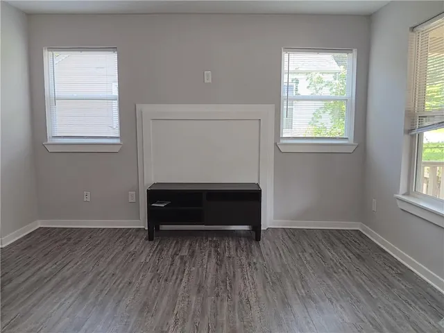 an empty room with wooden floor and window