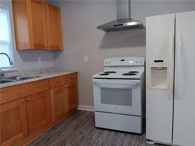 a kitchen with granite countertop white cabinets and white appliances