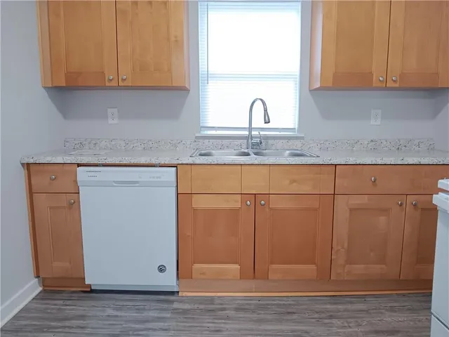a kitchen with granite countertop white cabinets and sink
