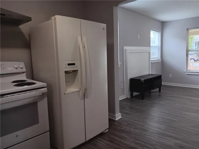 a kitchen with a refrigerator and a stove top oven