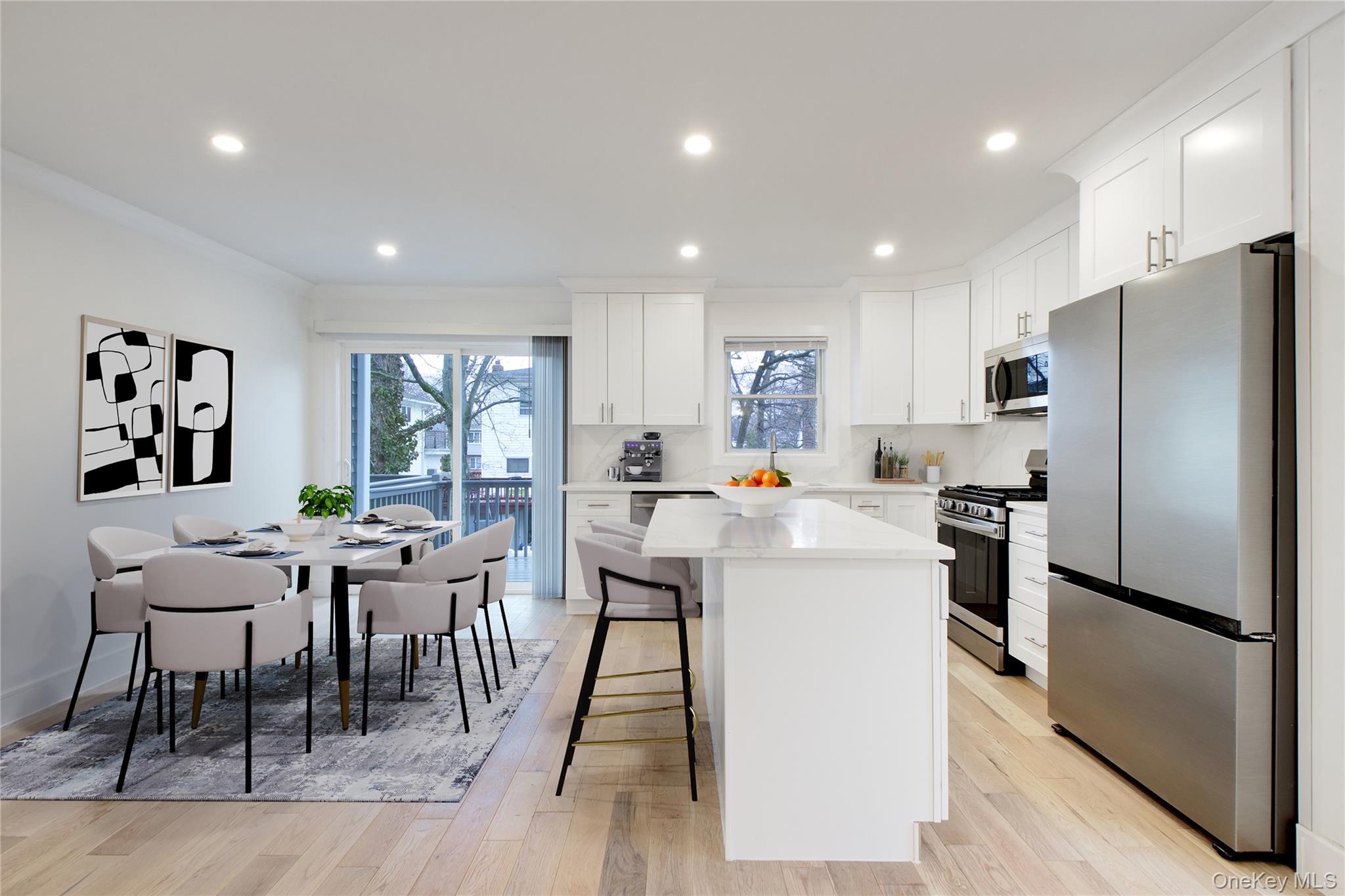 56 Kirkwood Road Port Washington, NY 11050 - Photo 13 of 46 a kitchen with a table chairs refrigerator and microwave